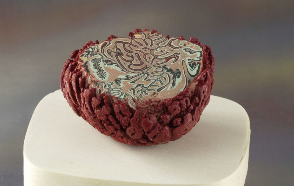 Encaustic sculptural bowl with a rough crimson exterior and a swirling marbled interior in rose and celadon tones.