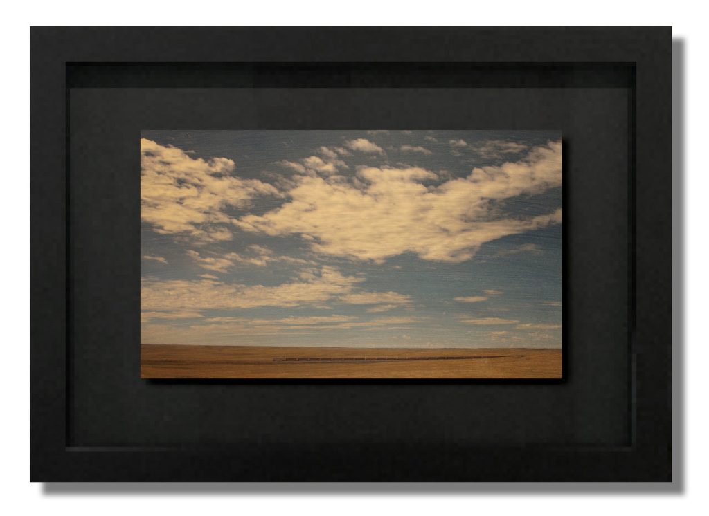 Painting of a flat prairie landscape under a wide sky filled with white cumulus clouds and warm ochre earth.