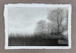 Ink drawing of a bare winter tree beside a dark field beneath a pale misty sky on textured paper.