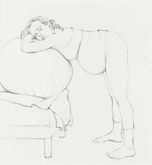 Pencil drawing of a nude woman slumped over a sofa cushion, head on arms, legs standing on the floor.
